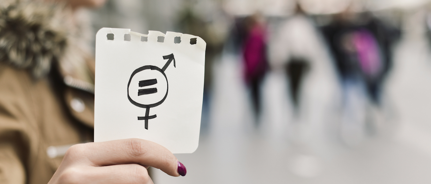 Foto: Frau hält Zettel mit Geschlechtergerechtigkeitssymbol in der Hand